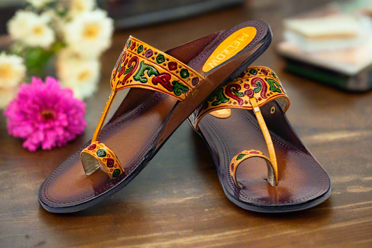 Pair of ornate sandals with colorful straps on a light background