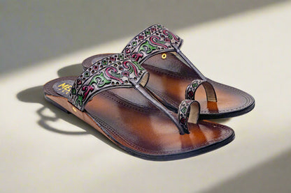 Brown sandal with decorative strap on a light background