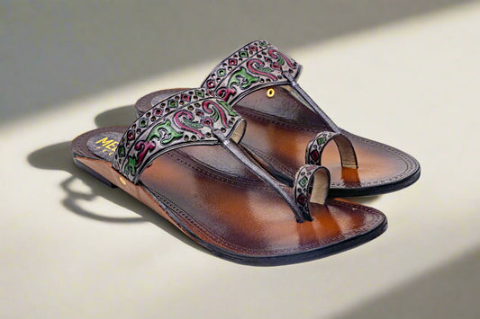 Brown sandal with decorative strap on a light background