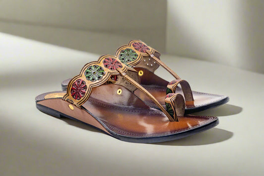 Brown sandal with decorative straps on a white background