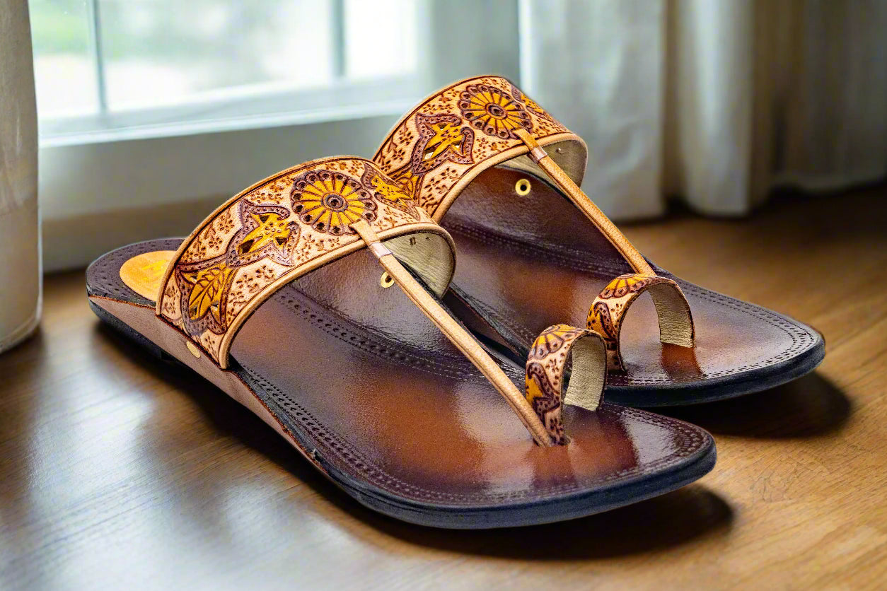 Brown sandal with decorative straps on a light gray background