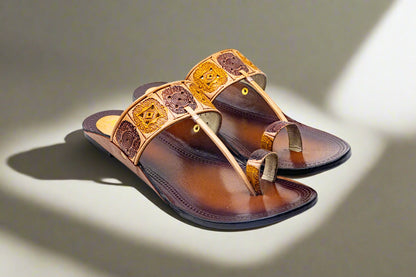 Handcrafted tan and brown leather flats with engraved square block motifs and dual-tone toe loop, representing traditional Indian artistry by Mellow Feets.