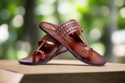 Pair of brown sandals with intricate design on a white background
