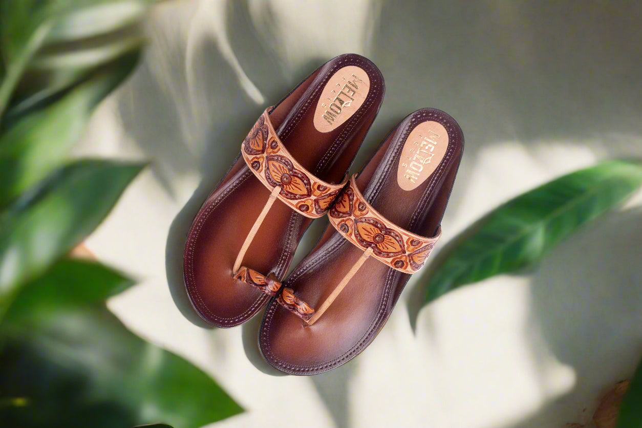 Pair of brown sandals with tan straps on a light background