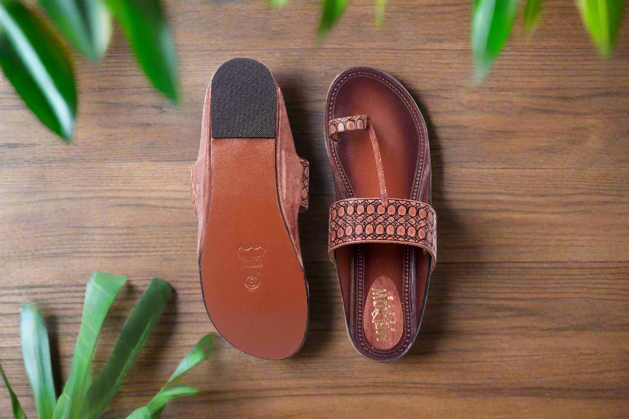 Brown sandal with a textured strap on a white background