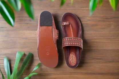 Brown sandal with a textured strap on a white background