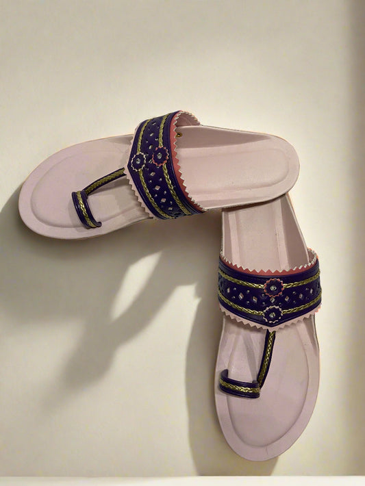 Traditional pink sole kolhapuri sandals with vibrant purple and red detailing on the broad strap, featuring floral accents and golden braided design.