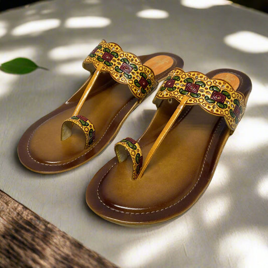 Pair of brown sandals with decorative straps on a white background