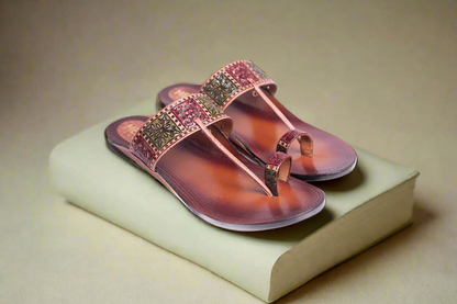 Pink sandals with gemstone embellishments on a beige surface