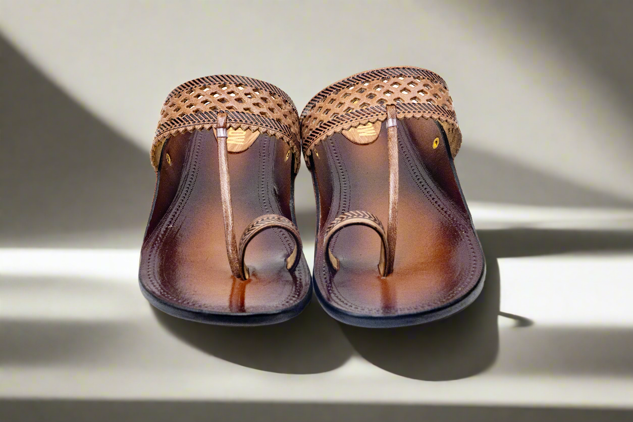 Pair of brown sandals with woven straps on a light background