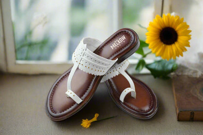 Traditional Indian Kolhapuri sandals in white with golden studs, displayed pair on white surface